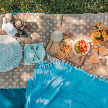 Blue and beige blankets with food laid out on it
